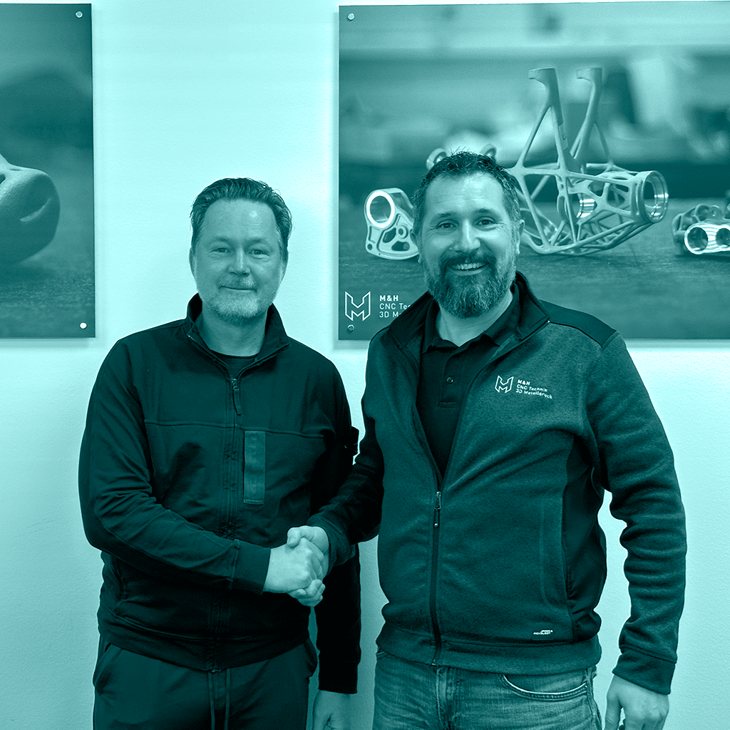 Sustainable metal partnership: California Metals CEO and M&H CEO shaking hands, cementing their collaboration on clean metal technologies for aerospace applications.
